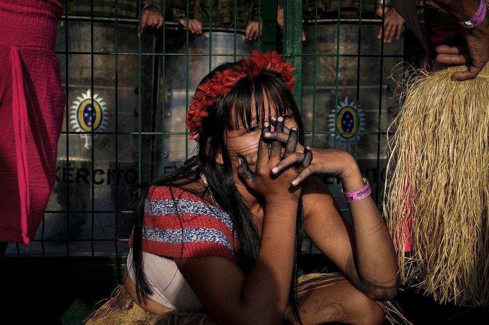 Jovem Munduruku durante protesto, agachada junto ao bloqueio do Exército, na entrada da Blue Zone (Foto: Fernando Martinho/Repórter Brasil)