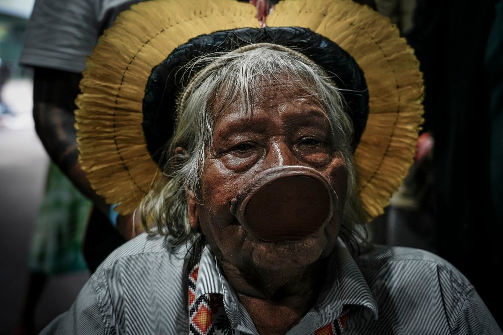 Retrato do cacique Raoni Metuktire, uma das principais lideranças indígenas do Brasil, chegando de cadeira de rodas para negociar com o presidente da COP30, André Corrêa do Lago, na Blue Zone (Foto: Fernando Martinho/Repórter Brasil)