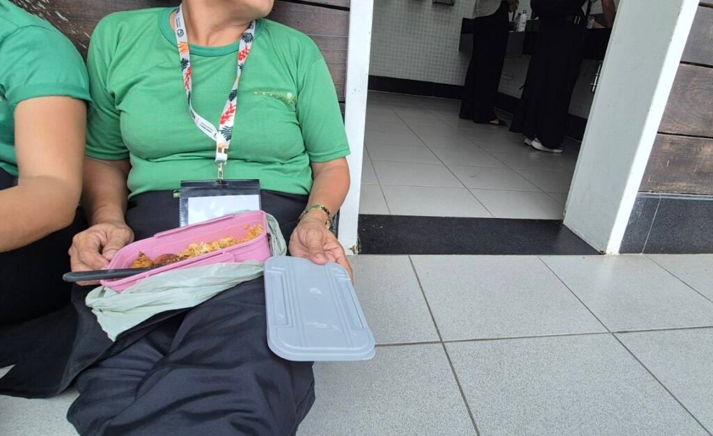 Sem refeitório, funcionários da limpeza comem no chão em frente a banheiros na COP30 (Foto: Hélen Freitas/Repórter Brasil)
